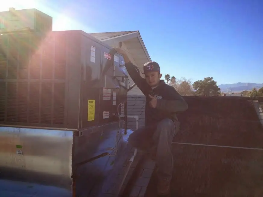 HVAC technician performing Boiler Repair on a rooftop unit in Potomac